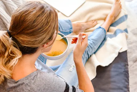   Kvinde derhjemme og spiser suppe