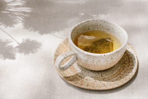   Egy csésze friss tea egy pikniken kívül a természet tükörképével