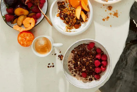   bord med skåle med frugt og granola