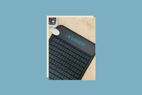   HigherDose PEMF Mat Review Hero with mat στον συγγραφέα's floor with remote control and blue backgorund