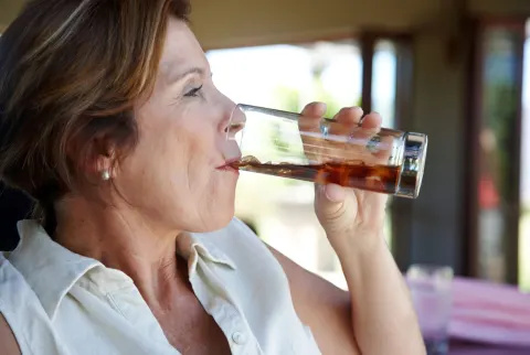 Mulher madura atraente bebendo refrigerante
