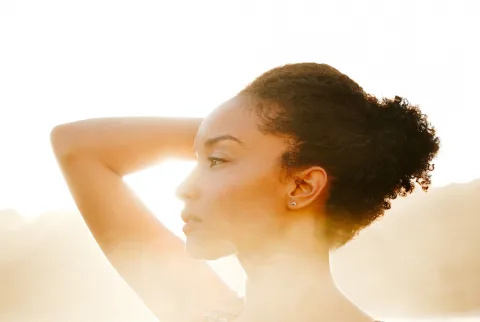 Close-up portret van een mooie jonge vrouw op het strand bij zonsondergang