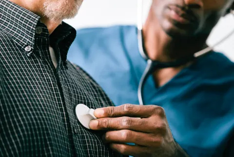   Médico examinando um paciente com um estetoscópio