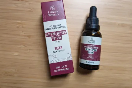  Lazarus Naturals Full-Spectrum Sleep Tincture polna neodprta steklenica poleg škatle na leseni mizi