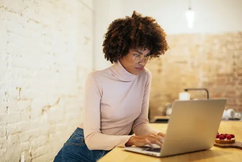   امرأة تكتب على الكمبيوتر