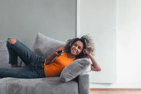 Smilende kvinde ser tv