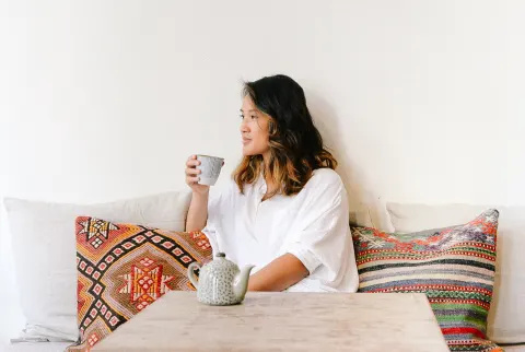 テーブルに座ってお茶を飲む女性