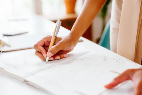 Onherkenbare vrouw die iets opschrijft in een planner