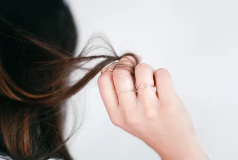 髪の一部を手に持つ女性