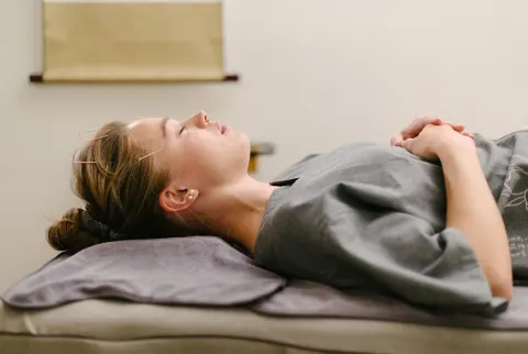   Mlada lijepa žena koja provodi postupak akupunkture kod liječnika tradicionalne kineske medicine