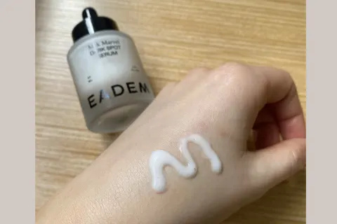 Eadem Milk Marvel Dark Spot Serum на руке рядом с бутылкой
