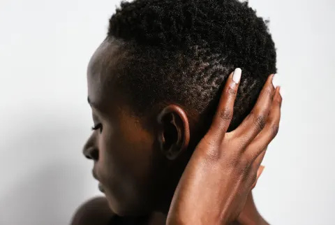 Kvindelig hånd rører afro frisure