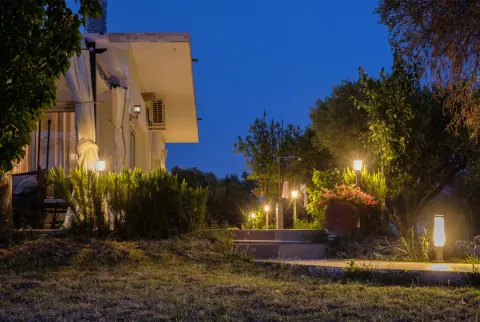 Gård og bungalow oplyst af lanterner. Nat ved havets kyst. stock foto