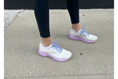 Кроссовки Brooks Ghost 15 на ногах на тротуаре в леггинсах